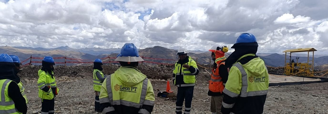 Cuadrilla con casco y chaleco reunida en círculo al aire libre