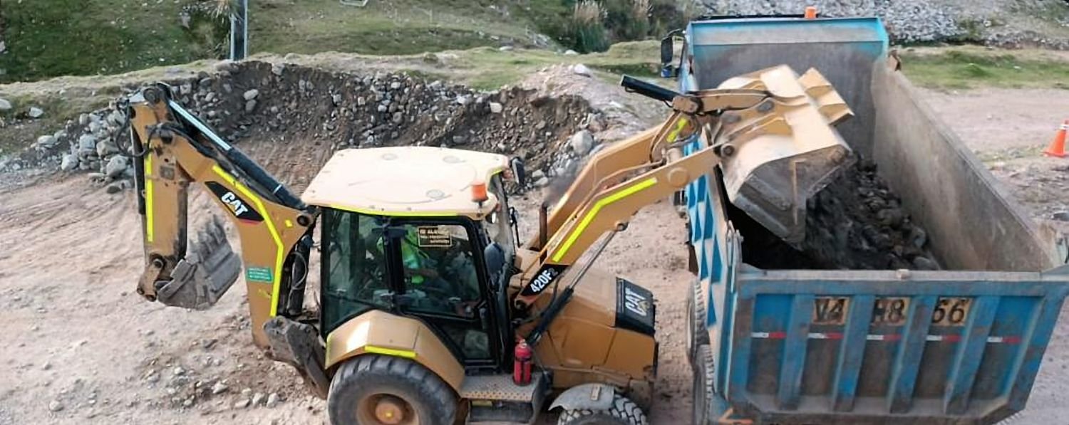 Retroexcavadora descargando material en la tolva de un volquete